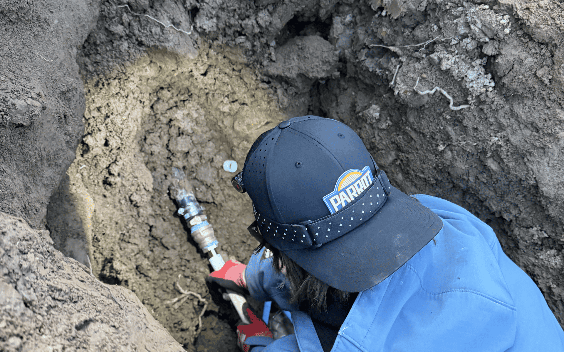 Plumber working on outdoor pipe lining